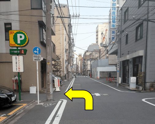Corner near a parking sign, arrow pointing left