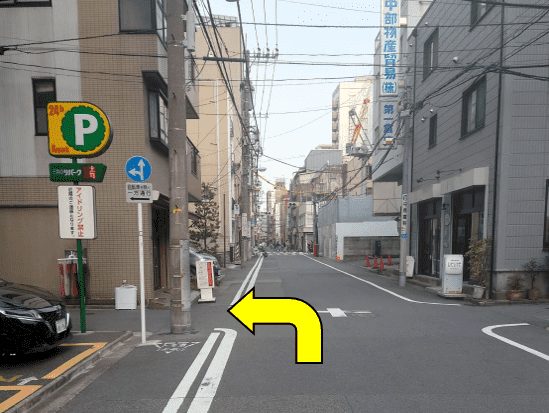 Corner near a parking sign, arrow pointing left