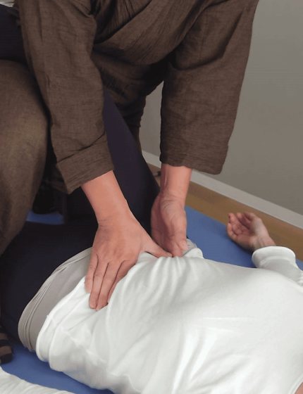 Hands working on a guest’s lower back