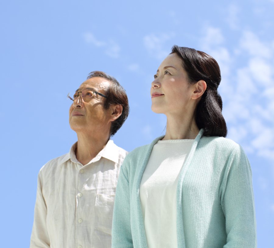 A woman holding the back of her neck, and an older couple looking up at a blue sky